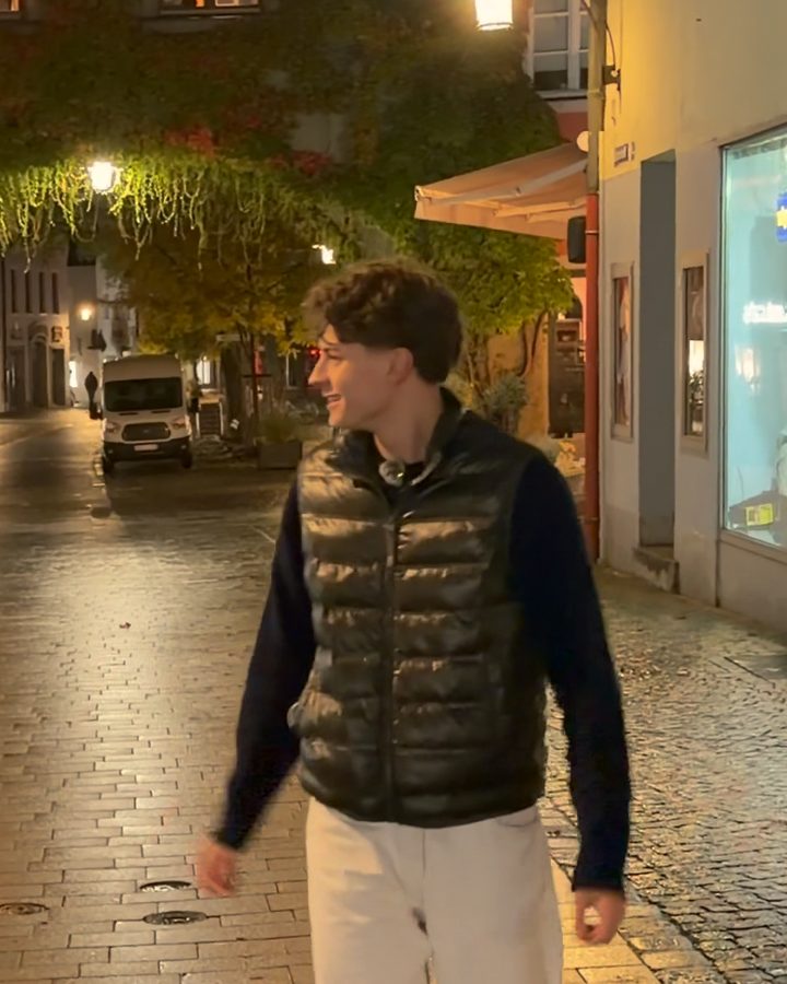 Valentin lacht in einer Altstadtgasse am Abend.